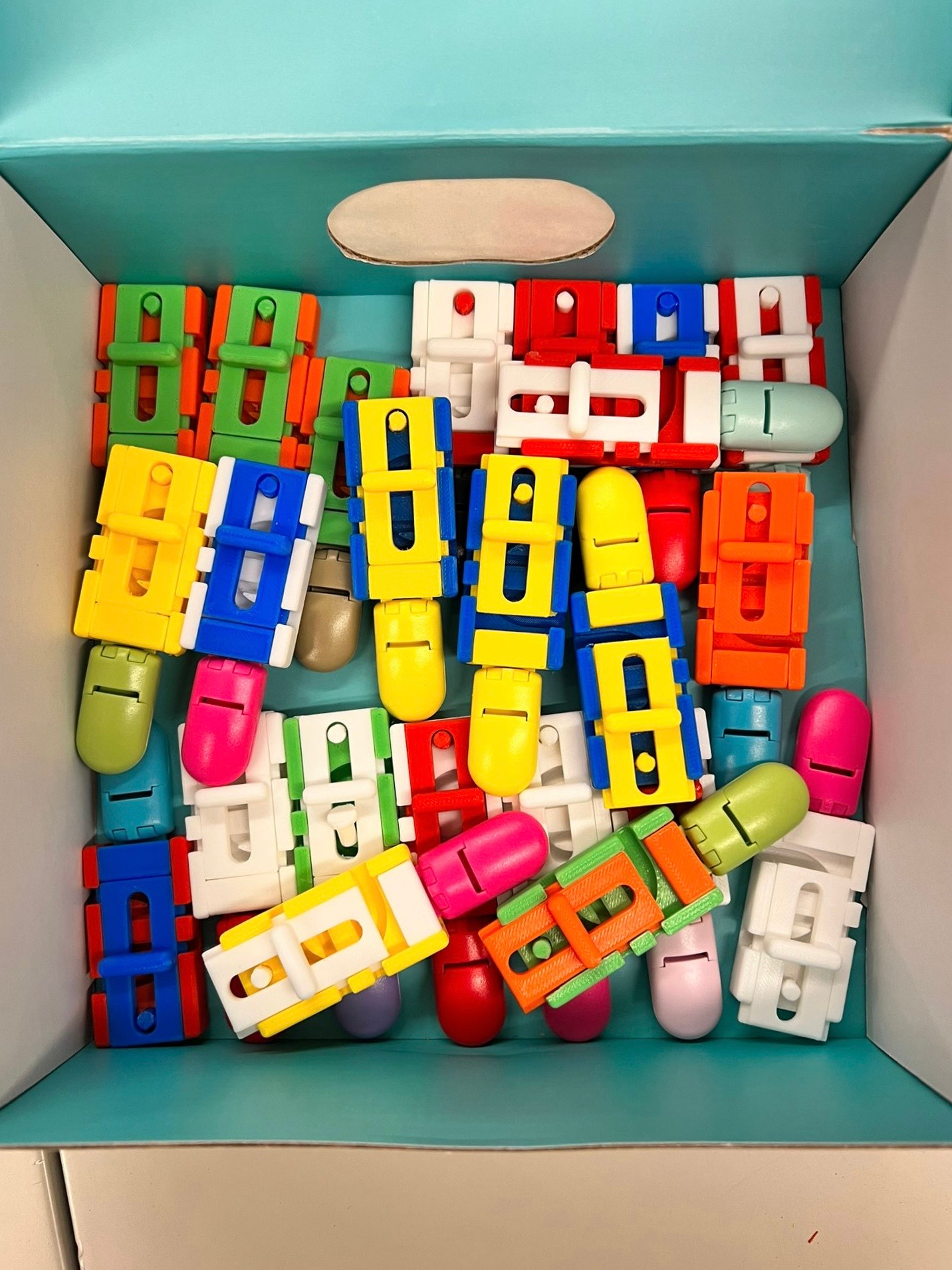 A box full of colorful 3D-printed clamp prototypes